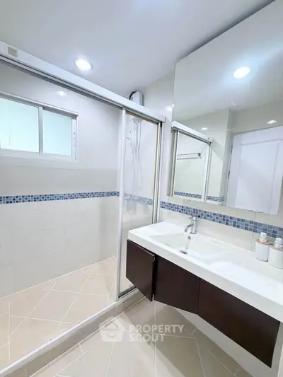 Modern bathroom with sleek shower and stylish vanity in contemporary home.