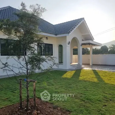 Charming single-story home with lush green lawn and modern architecture, perfect for serene living.