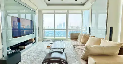 Spacious living room with panoramic city views and modern furnishings.