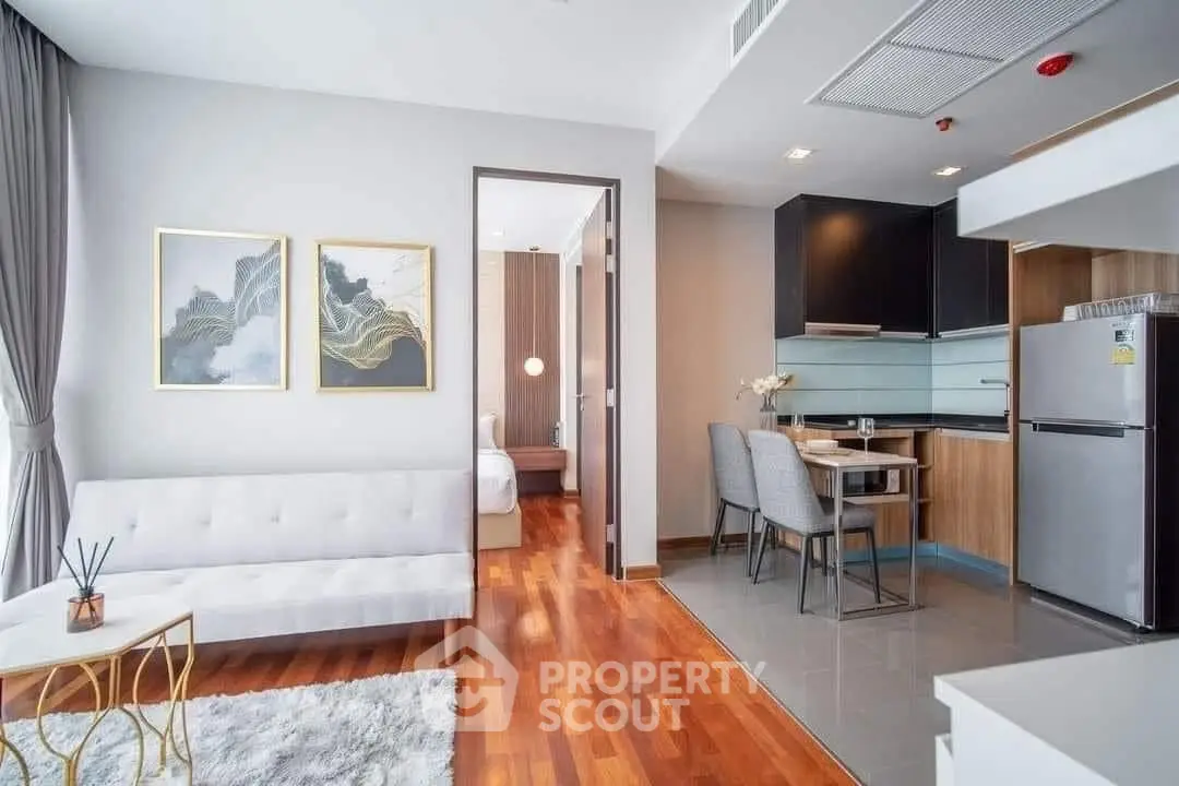 Modern open-plan living room and kitchen with elegant decor and hardwood floors
