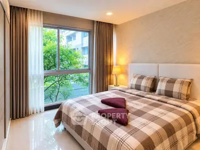 Cozy bedroom with large window and stylish decor in modern apartment