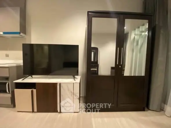 Modern living room with sleek TV stand and elegant wardrobe, perfect for stylish urban living.