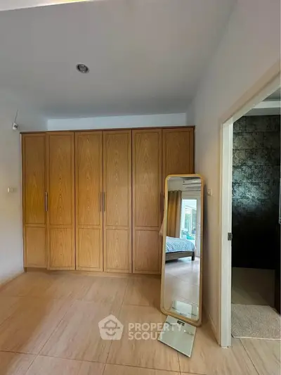 Spacious bedroom with wooden wardrobe and stylish floor mirror