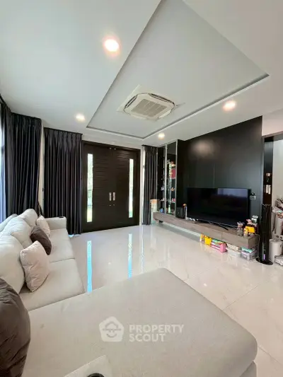 Spacious modern living room with sleek design and large sectional sofa, perfect for relaxation and entertainment.