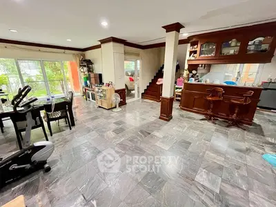 Spacious open-plan living area with modern kitchen and dining space, featuring elegant flooring and natural light.
