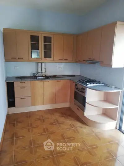 Spacious kitchen with modern cabinets and gas stove, perfect for culinary enthusiasts.