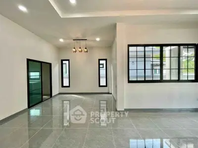 Spacious modern living room with large windows and elegant lighting