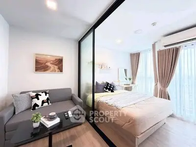 Modern studio apartment with glass partition, cozy living area, and stylish bedroom.