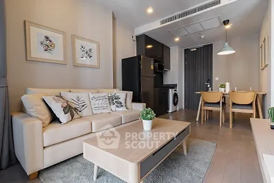 Modern living room with cozy sofa, dining area, and sleek kitchen appliances in open layout.