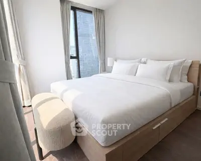 Modern bedroom with large window and elegant decor in a high-rise apartment.