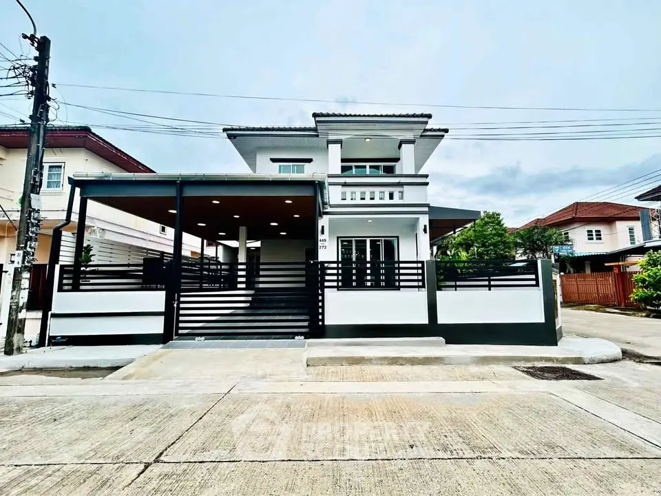 Modern two-story house with sleek design and spacious driveway in suburban neighborhood.