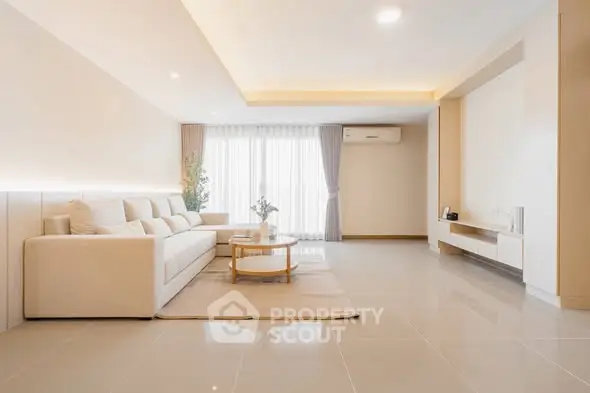 Spacious modern living room with elegant decor and large windows.