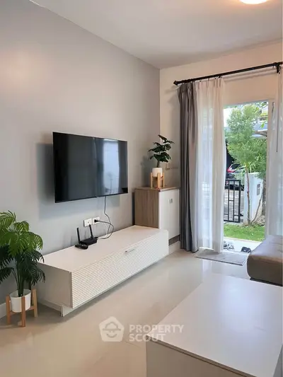 Modern living room with sleek TV setup and garden view