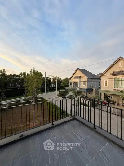 Spacious balcony with scenic neighborhood view and modern railing design.