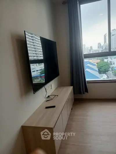 Modern living room with wall-mounted TV and city view from window