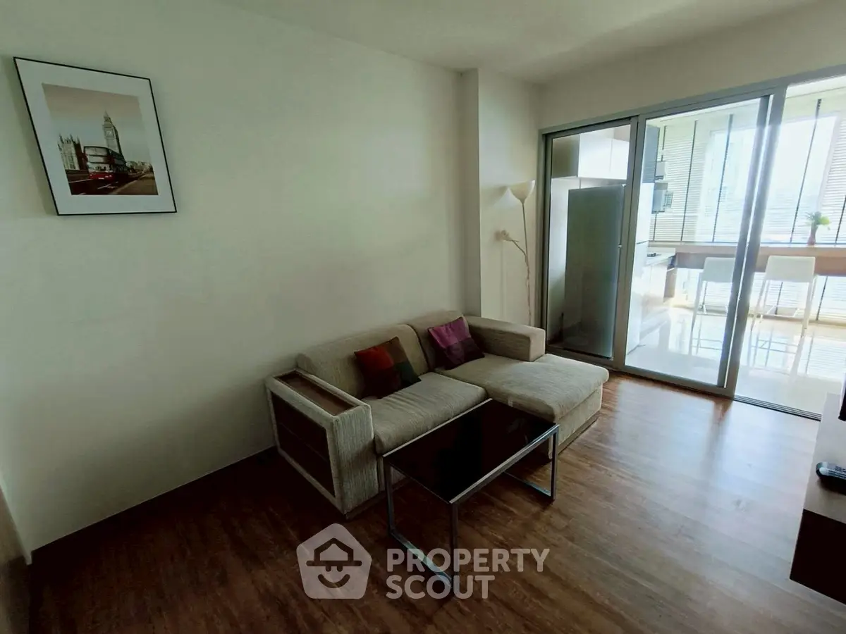 Modern living room with cozy sofa and balcony view, perfect for relaxation.