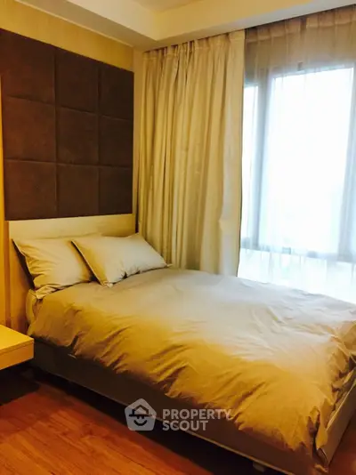 Cozy bedroom with modern decor and large window for natural light