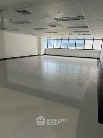 Spacious and well-lit commercial office space with large windows offering ample natural light, ideal for businesses seeking a modern and efficient work environment.