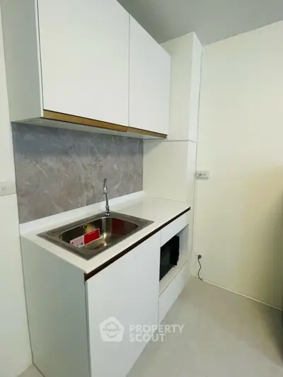 Modern compact kitchen with sleek cabinetry and built-in appliances