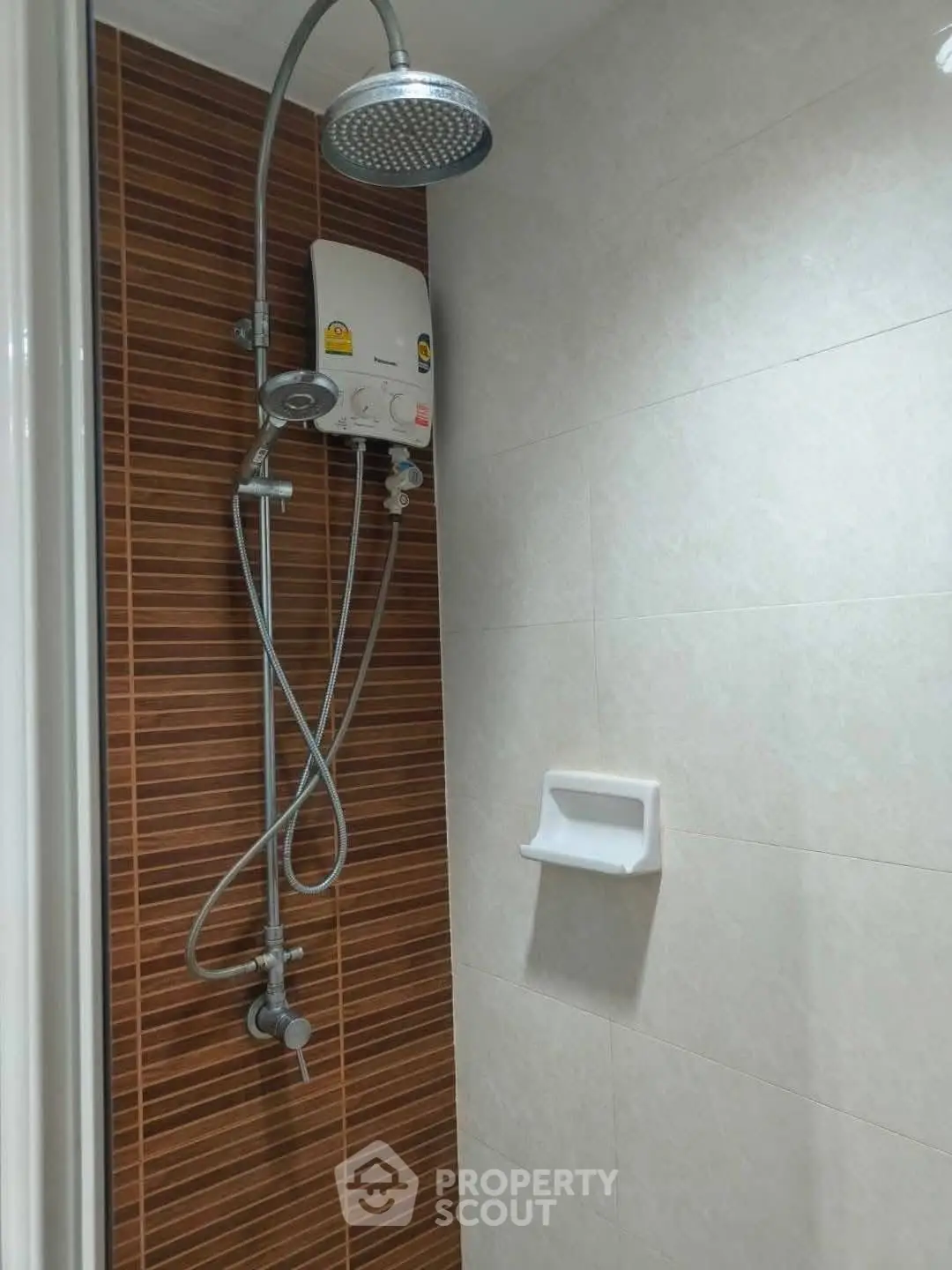 Modern bathroom shower with water heater and sleek tile design.