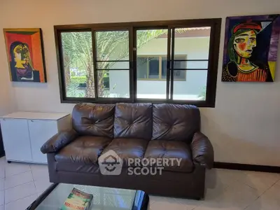 Cozy living room with leather sofa and vibrant artwork, perfect for relaxation and style.