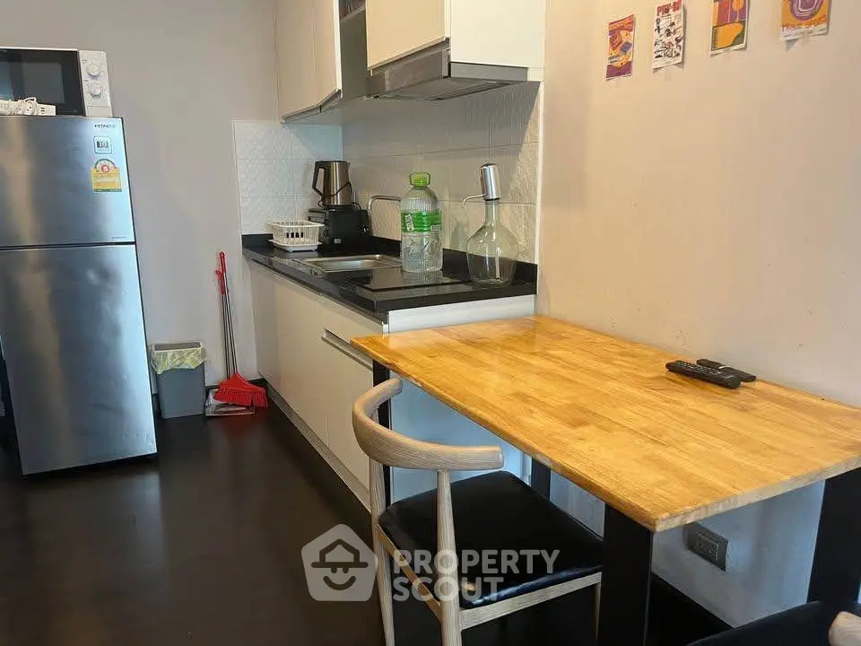 Modern compact kitchen with sleek appliances and cozy dining area, perfect for urban living.