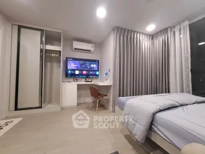 Modern bedroom with sleek design, featuring a wall-mounted TV, air conditioning, and stylish furnishings.