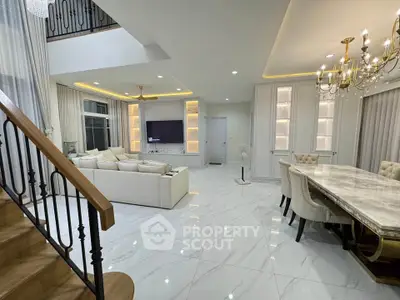 Luxurious open-plan living and dining area with elegant chandelier and modern decor