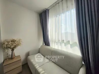 Cozy living room with modern sofa and elegant curtains, perfect for relaxation.