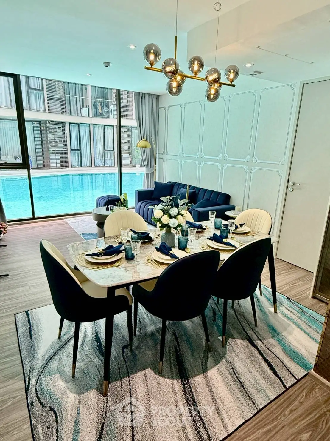 Luxurious living room with pool view, elegant dining setup, and modern decor