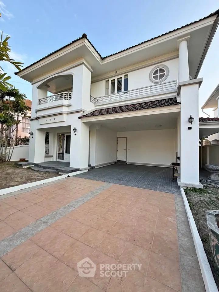 Elegant two-story house with spacious driveway and modern architectural design.