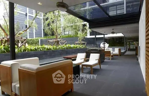 Luxurious outdoor seating area with modern design and lush greenery in a high-end residential complex.
