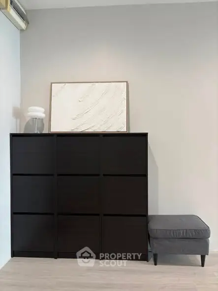 Modern minimalist interior with sleek black storage unit and stylish decor