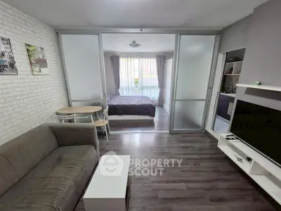 Modern studio apartment with sliding glass doors and cozy living area.