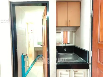 Compact bathroom with sink and shower in modern apartment