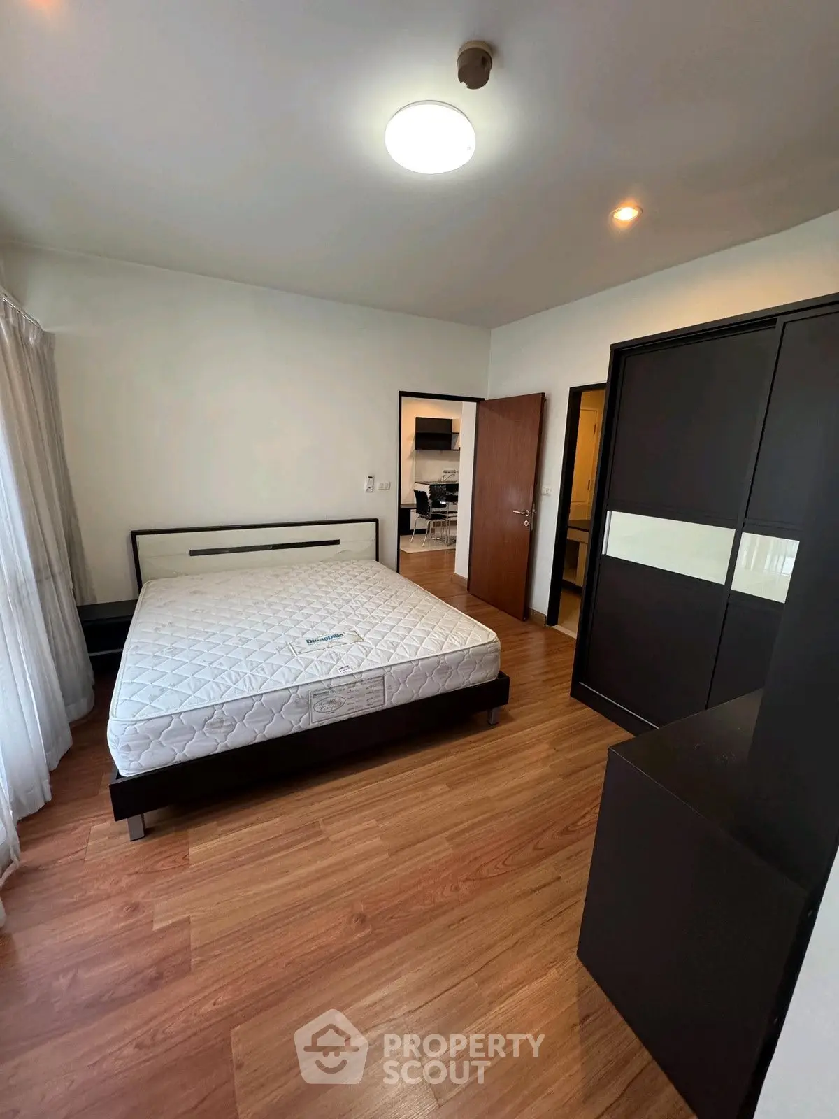 Spacious bedroom with modern furniture and wooden flooring