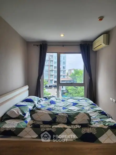 Cozy bedroom with large window offering city view, modern decor and air conditioning.