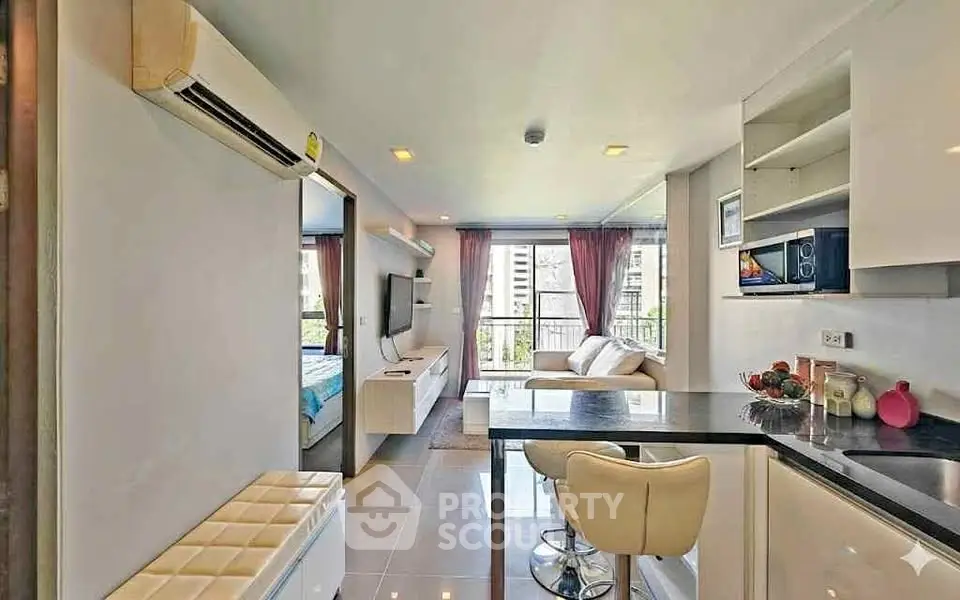 Modern open-plan living room with sleek kitchen and stylish decor in a bright apartment.