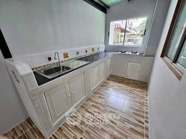 Charming kitchen with modern tiled flooring and ample natural light