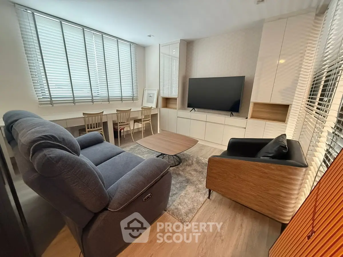 Modern living room with stylish furniture and large TV, perfect for relaxation.