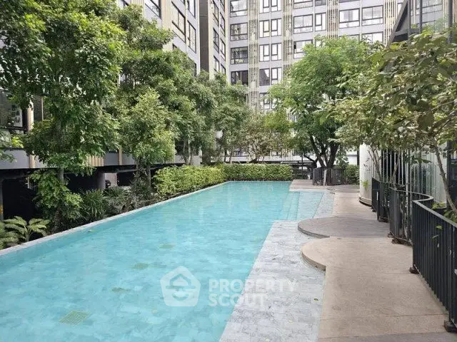 Luxurious residential pool surrounded by lush greenery and modern architecture.