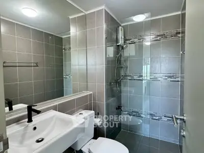 Modern bathroom with sleek design, featuring glass shower and stylish fixtures.