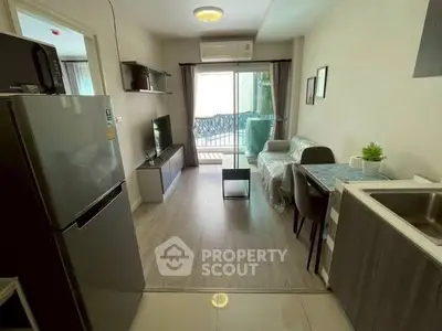 Modern living room with balcony access and sleek kitchen area