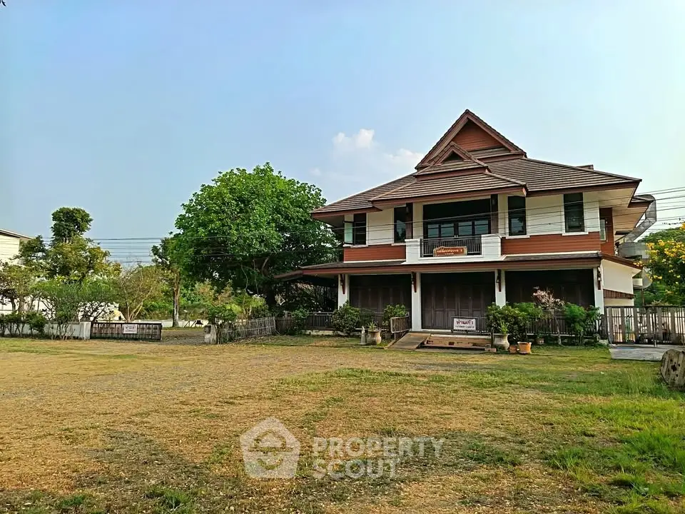 Charming traditional two-story house with spacious yard and lush greenery, perfect for serene living.