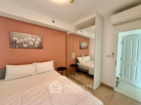 Cozy bedroom with mirrored wardrobe and stylish decor in modern apartment.