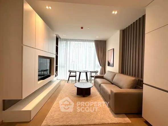 Modern living room with sleek furniture and large windows offering city views.