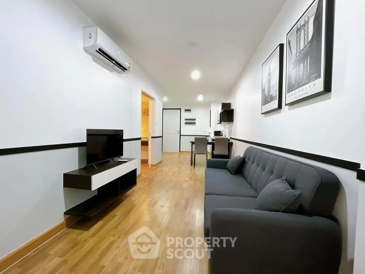 Modern living room with sleek furniture and open kitchen layout, perfect for urban living.