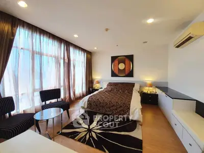 Luxurious bedroom with modern decor and large windows offering natural light
