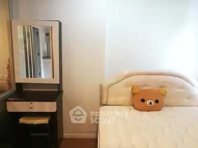 Cozy bedroom with plush headboard and stylish vanity in modern apartment.
