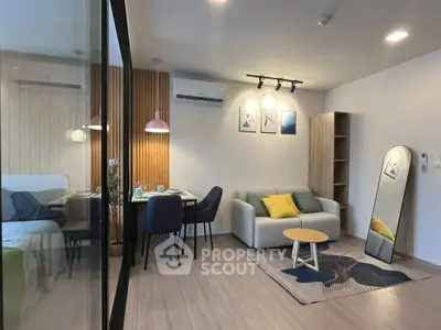 Modern living room with stylish decor and dining area, featuring sleek furniture and ambient lighting.